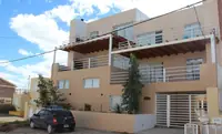 Frente del Complejo Luminar en Las Grutas: edificio de tres plantas con balcones y cocheras