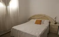 Dormitorio del departamento de 2 ambientes del Complejo Luminar en Las Grutas, con cama doble y mesa de luz
