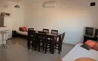 Living del departamento de 2 ambientes del Complejo Luminar en Las Grutas, con aire acondicionado, sofás cama y barra desayunadora