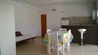 Monoambiente del Complejo Luminar en Las Grutas: comedor, cocina con barra desayunadora y cama junto al placard