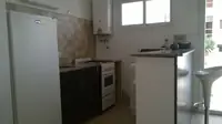 Cocina del monoambiente Luminar en Las Grutas con heladera, horno, microondas y barra desayunadora