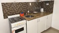 Cocina equipada del departamento Pewmafe en Las Grutas con horno, anafe, mesada de granito y bacha