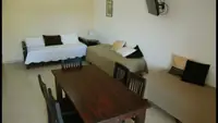Living del Departamento LG en Las Grutas con sofás cama, mesa comedor y Smart TV