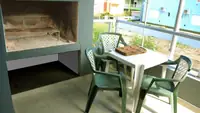 Balcón solárium del Departamento LG en Las Grutas con parrilla propia, mesa y sillas
