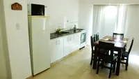 Cocina integrada del Departamento LG en Las Grutas con heladera, microondas, horno y mesada