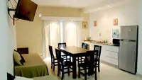 Comedor del Departamento LG en Las Grutas con mesa para seis, Smart TV, cocina y heladera