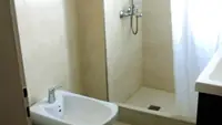 Baño del Departamento LG en Las Grutas con ducha, mampara de vidrio y bacha