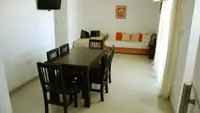 Living del Departamento LG en Las Grutas con Smart TV, sofás cama y acceso al balcón