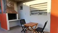 Patio individual del departamento Pewmafe en Las Grutas con parrilla de ladrillo, mesa y sillas